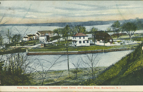 This image depicts Lock 1 and the southern terminus of the main canal in Bordentown. The white building is the toll collector’s office of the Delaware and Raritan Canal Company, while the mule stables are seen on the left.  For much of the canal’s history, the company’s buildings and structures were whitewashed in the spring.
